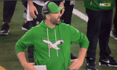 Man In Green Sweatshirt With Eagle And Sony Hat On Football Field GIF