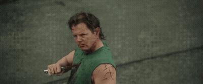 Man In Green Tank Top Holding Knife Smiling GIF