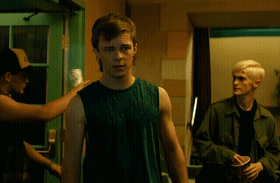 Man In Green Tank Top In Front Of Green Door GIF