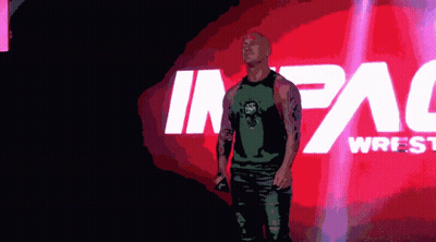 Man In Green Tank Top In Front Of Impact Wrestling Logo GIF