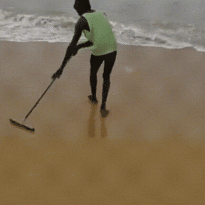 Man In Green Tank Top Standing On Beach GIF