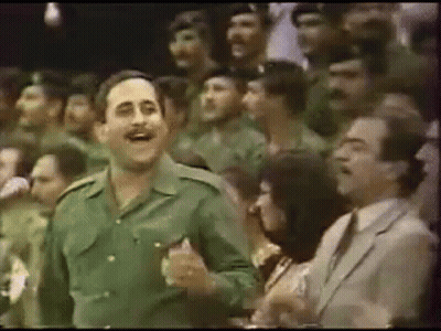 Man In Green Uniform Dancing Before Crowd GIF