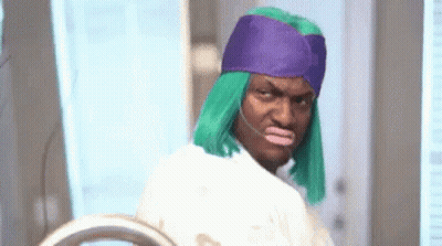 Man In Green Wig And Purple Hat At Mirror GIF