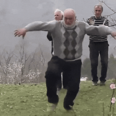 Man In Grey And Black Sweater Dancing In Field GIF