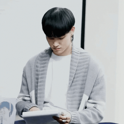 Man In Grey Cardigan Reading Book GIF