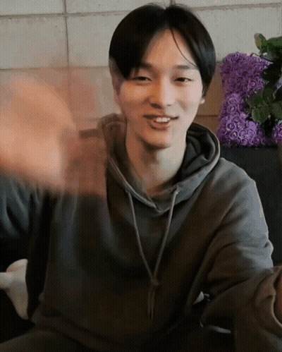 Man In Grey Hoodie Smiling And Waving GIF