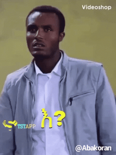 Man In Grey Jacket With Question Mark Shirt GIF
