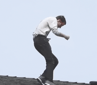 Man In Grey Shirt And Black Pants Walking On Wooden Roof GIF