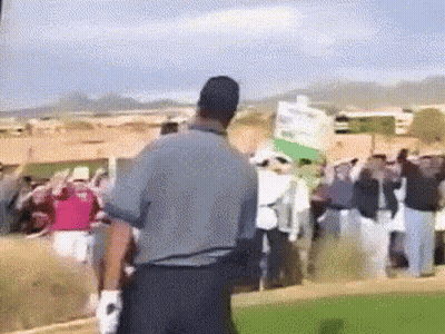 Man In Grey Shirt Holding Signs In Crowd GIF