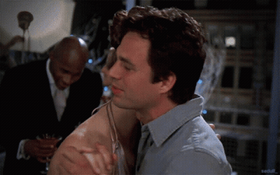 Man In Grey Shirt Hugging Woman In Front Of Man In Suit GIF