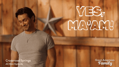 Man In Grey Shirt In Front Of Yes Ma'am Wall GIF