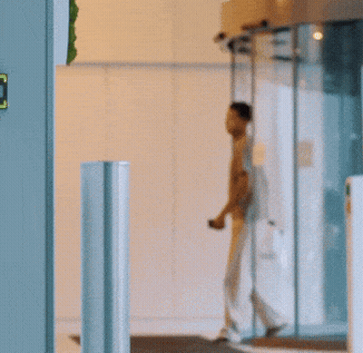 Man In Grey Shirt Walking Through Round Door GIF