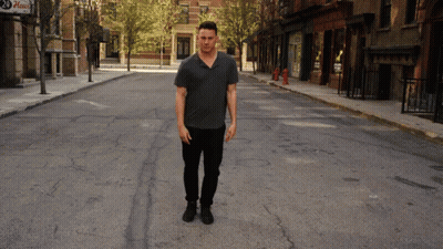Man In Grey Shirt Walking With Pizza Sign GIF