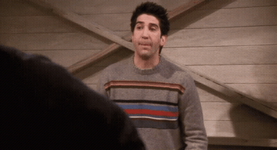 Man In Grey Striped Sweater In Front Of Wooden Wall GIF