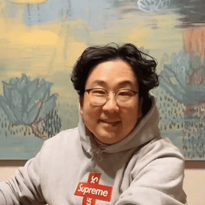 Man In Grey Supreme Hoodie With Red Logo GIF