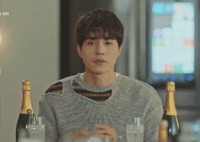 Man In Grey Sweater Sitting At Table With Champagne GIF