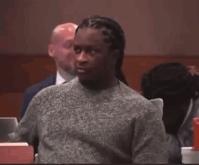 Man In Grey Sweater Sitting In Courtroom GIF