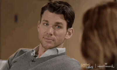 Man In Grey Sweater Smiling In Front Of Woman Hallmark Spring Into Love Movie GIF