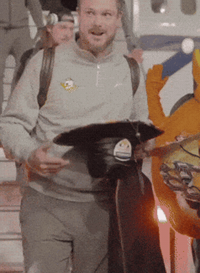Man In Grey Sweatshirt With Bird Holding Black Hat GIF