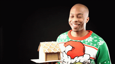 Man In Grinch Sweater Holding Gingerbread House GIF