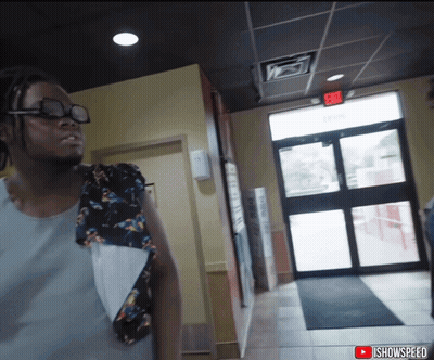 Man In Hallway With Red Exit Sign GIF