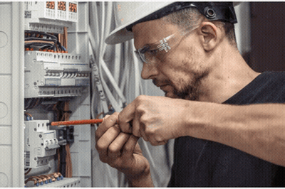 Man In Hard Hat And Safety Glasses Working On Circuit Board GIF