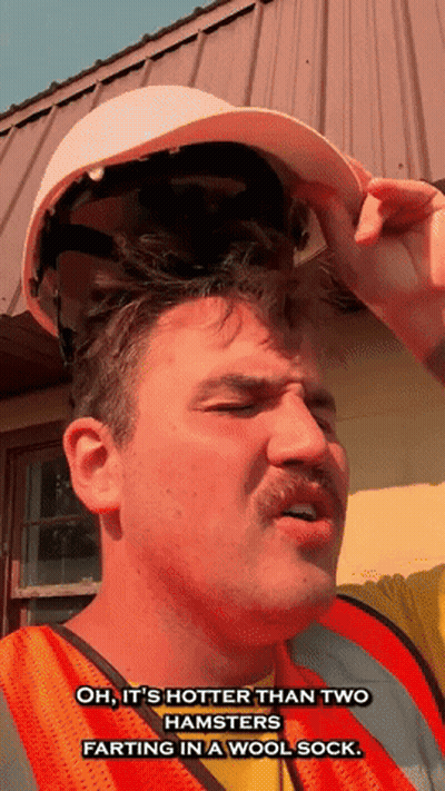 Man in Hard Hat and Safety Vest Saying It's Hot