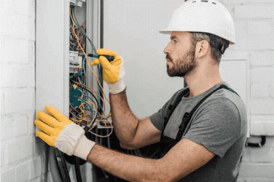 Man In Hard Hat And Yellow Gloves Working On Electrical Box GIF
