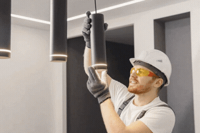 Man In Hard Hat Hanging Light From Ceiling GIF