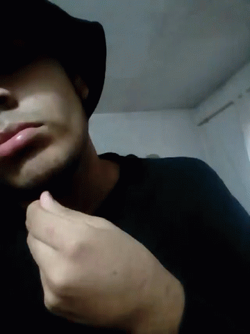 Man In Hat And Black Shirt Hand To Chin GIF