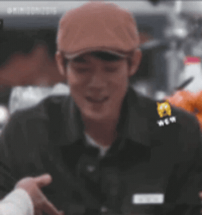 Man In Hat And Black Shirt Smiling Holding Hand GIF