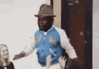 Man In Hat And Blue Jacket Dancing In Front Of Woman GIF