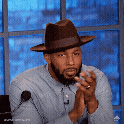 Man In Hat And Blue Shirt Clapping At Microphone GIF