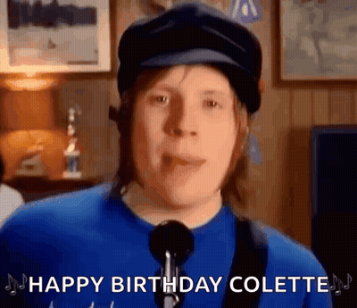 Man In Hat And Blue Shirt Singing Into Microphone GIF