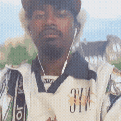 Man In Hat And Ear Buds With Zyi Shirt GIF