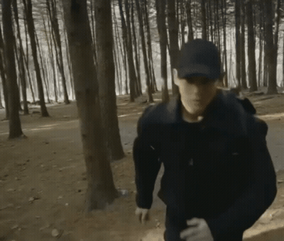Man In Hat And Gloves Running Through Forest GIF