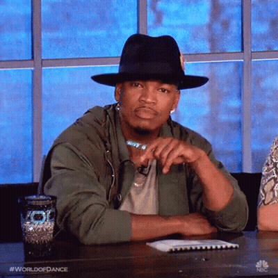 Man In Hat And Green Jacket Sitting With Hands Folded GIF