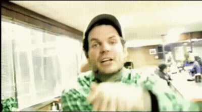 Man In Hat And Green Shirt Making Funny Face In Restaurant GIF