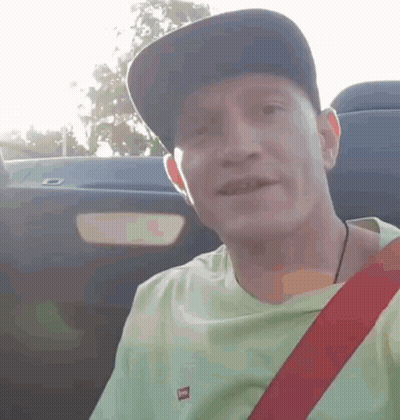 Man In Hat And Green Shirt Smiling In Car GIF