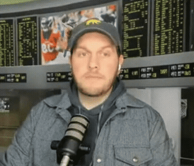 Man In Hat And Jacket At Microphone GIF