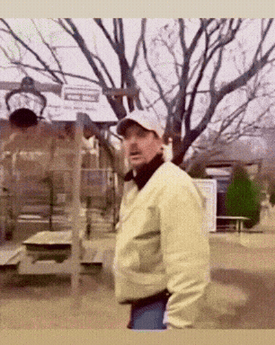 Man In Hat And Jacket Standing In Park GIF