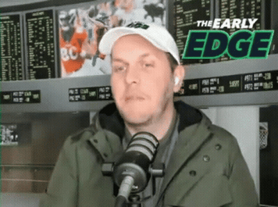Man In Hat And Jacket Talking Into Mic GIF