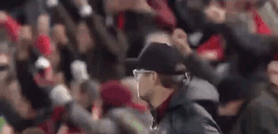 Man In Hat And Jacket Walking In Front Of Crowd GIF