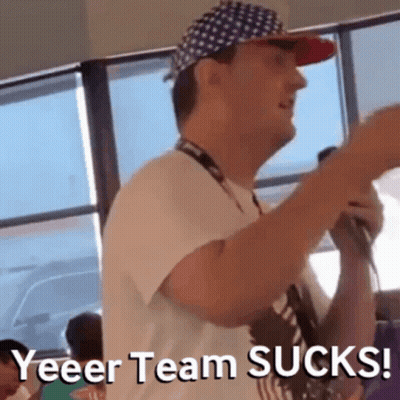 Man In Hat And Lanyard Holding Microphone Says Yeeer Team Sucks GIF
