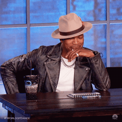 Man In Hat And Leather Jacket At Table With Cup And Notebook GIF