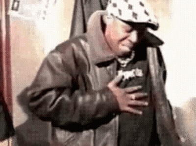 Man In Hat And Leather Jacket Holding Chest In Pain GIF