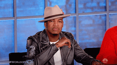 Man In Hat And Leather Jacket In Front Of NBC Sign GIF
