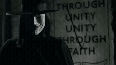 Man In Hat And Mask Standing In Front Of Through Unity Through Faith Sign GIF