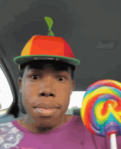 Man In Hat And Purple Shirt Holding Lollipop GIF