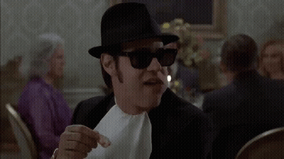 Man in Hat and Sunglasses Eating Bread